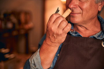 Male winemaker enjoying the scent of wine cork