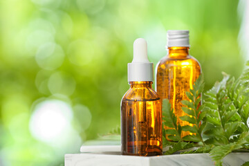 Bottles of essential oil on table outdoors, closeup