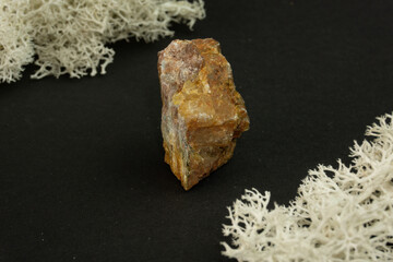 Andalusite from Brazil or China. Natural mineral stone on a black background surrounded by moss....