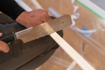 配線モールをノコギリで切る作業風景