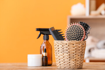 Basket with hairdresser's tools and cosmetics on table in room