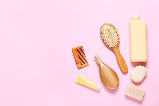 Hair brush, comb and cosmetics on color background