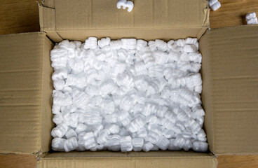 A cardboard box with packing foam top view, Delivery box for fragile product on wooden table