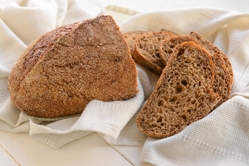 Fresh wholegrain bread on white wooden background