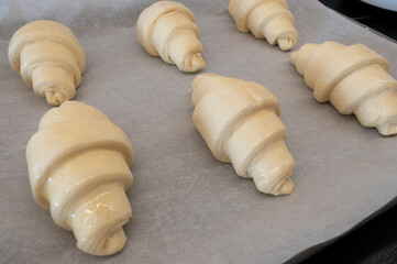 Fototapeta na wymiar Croissant on board with baking paper for homemade breakfast