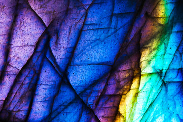 Detail of colorful multicolored (blue, yellow, purple, cyan) labradorite gemstone. Close-up of the...