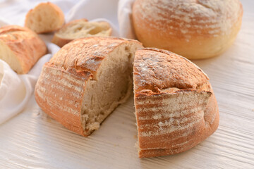 Loaf of sourdough bread on white wooden background