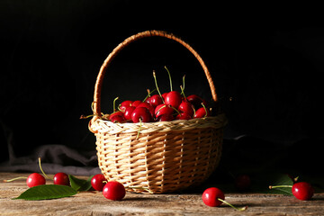 Fototapeta na wymiar Basket with tasty ripe cherry on wooden table