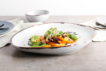 Plate with tasty tomato carpaccio on grey background