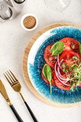 Plate with tasty tomato carpaccio on light background