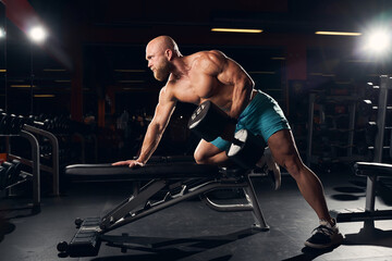 Sporty bald man working out in the gym