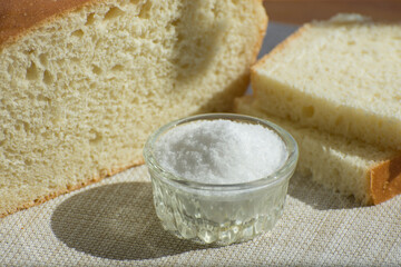 Fresh homemade bread, slices of bread and salt on the table. Simple traditional food.