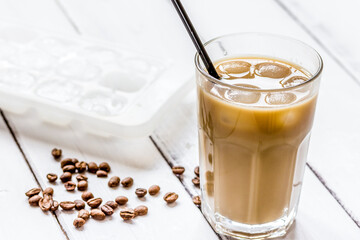 coffee ice cubes and beans with latte on white desk background