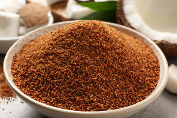 Natural coconut sugar in ceramic bowl on table, closeup