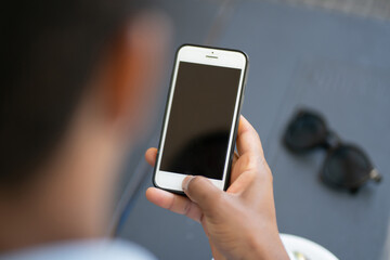 Man holding mobile phone with black screen.