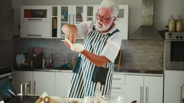 Old Grandfather Trying Throwing Pizza Dough In The Air With One Hand