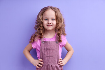 Obraz na płótnie Canvas Caucasian Smiling Child Girl Isolated On Purple Background, Look At Camera, Posing, In Casual Outfit. Children, People Lifestyle Concept