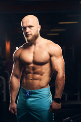 Fototapeta na wymiar Handsome muscular man standing shirtless at the gym