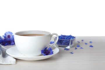 Cornflower tea and fresh flowers on white wooden table