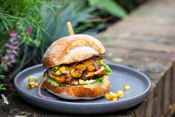 Rustic bread roll with chipotle chicken, grilled swet corn and avocado
