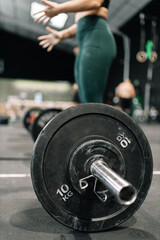 Young fitness woman doing barbell squats in a gym