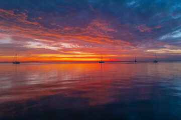 Fototapeta premium Ocean sunset on sky background with colorful clouds. Calm sea with sunrise sky.