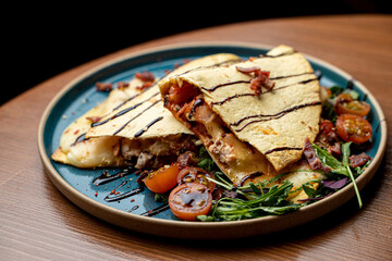 Ground beef quesadilla with spicy sauce and salad, neat restaurant photo
