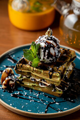 Close up of gourmet brussels waffles with vanilla ice cream and blueberry sauce