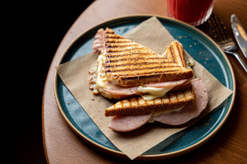 Grilled sandwich with melted mozzarella and ham, appetizing photo for instagram page of a coffee house