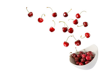 Fresh  ripe cherry berries falling into bowl isolated on white background. - Powered by Adobe