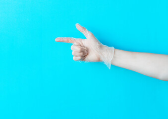 Human hand in transparent glove above bright blue background with copy space. Safety and selfcare concept