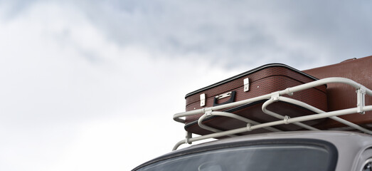 trip on retro car with suitcases on roof rack