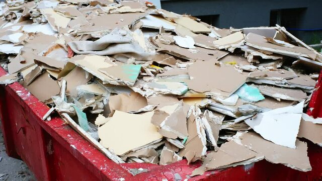 Pile of Hazardous Construction Materials Waste In Large Metal Garbage Dump Container Bin
