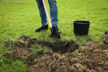 Worker digging soil with shovel outdoors, closeup © New Africa