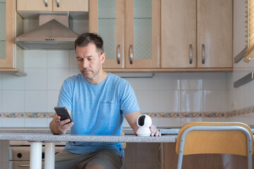 Man setting up security camera with his smartphone.