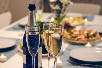 Beautiful table setting for home party. Fne dining with and glassware, candles and champagne.