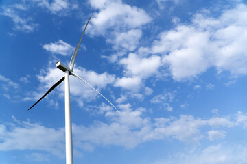 Wind turbine main rotor over blue cloudy sky
