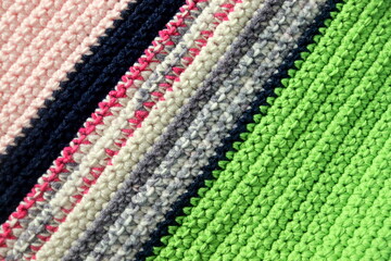 Knitted background, knitted wallpaper, knitted fabric, ricotted texture. Soft material. Handmade carpet closeup photo. Cozy background. Knitted details. 