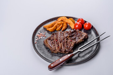 Delicious juicy fresh beef steak with spices and herbs on a white background