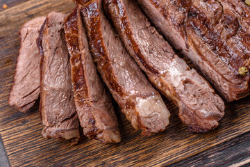 Delicious juicy fresh beef steak with spices and herbs on a dark concrete background