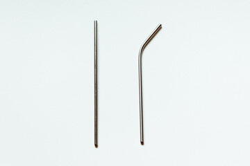 Two metal reusable straws for drinks on a white background.