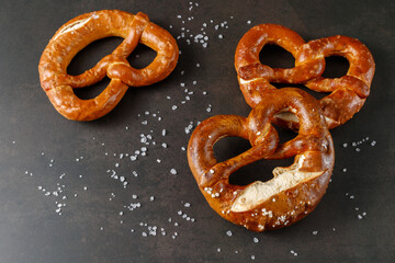 Traditional baked bavarian salty bread pretzels closeup  on brown rustic stone background.