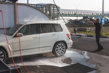 Man washing his car on self service car washing station