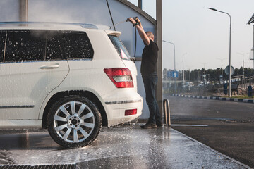 Man washing his car on self service car washing station
