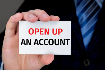 Closeup on businessman holding a card with OPEN UP AN ACCOUNT message, business concept image with soft focus background