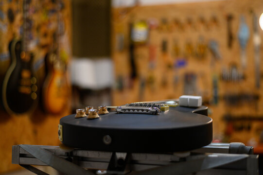 Black electrical guitar in a service repair workshop
