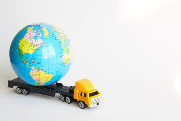 Globe on a toy truck with a trailer. The concept of worldwide delivery of goods and parcels, collection, work with fragile and important orders. Free space for an inscription
