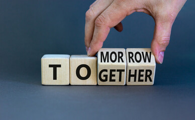 Tomorrow we will together symbol. Businessman turns wooden cubes and changes the word together to tomorrow. Beautiful grey background, copy space. Business and tomorrow we are together concept. - obrazy, fototapety, plakaty