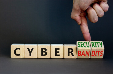 Cyber-security vs cyber-bandits symbol. Businessman turns wooden cubes, changes words Cyber-bandits to cyber-security. Beautiful grey background. Cyber-security vs cyber-bandits concept. Copy space.