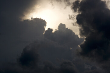 Thick storm clouds fill the sky and surround the sun, obscuring it from view.